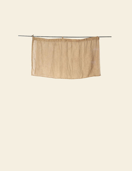 Beige curtain on a rod against a beige background