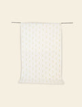 White pillow with gold polka dots on a beige background