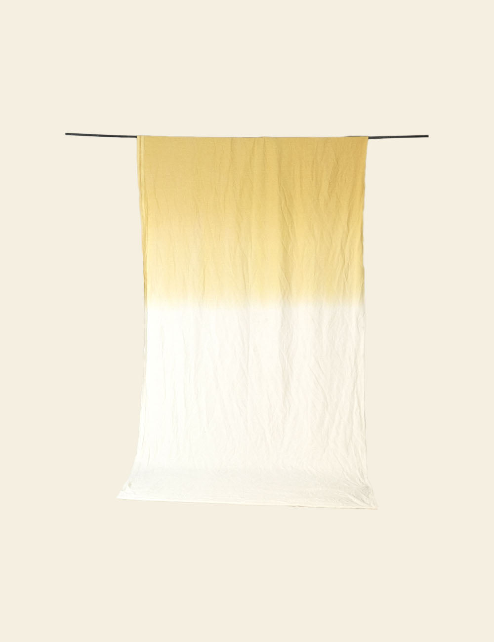 Gradient scarf transitioning from yellow to white on a beige background