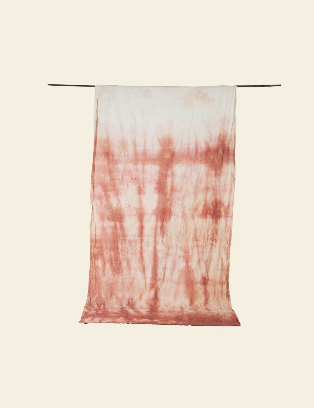 Tie-dye towel with red and white pattern on a beige background