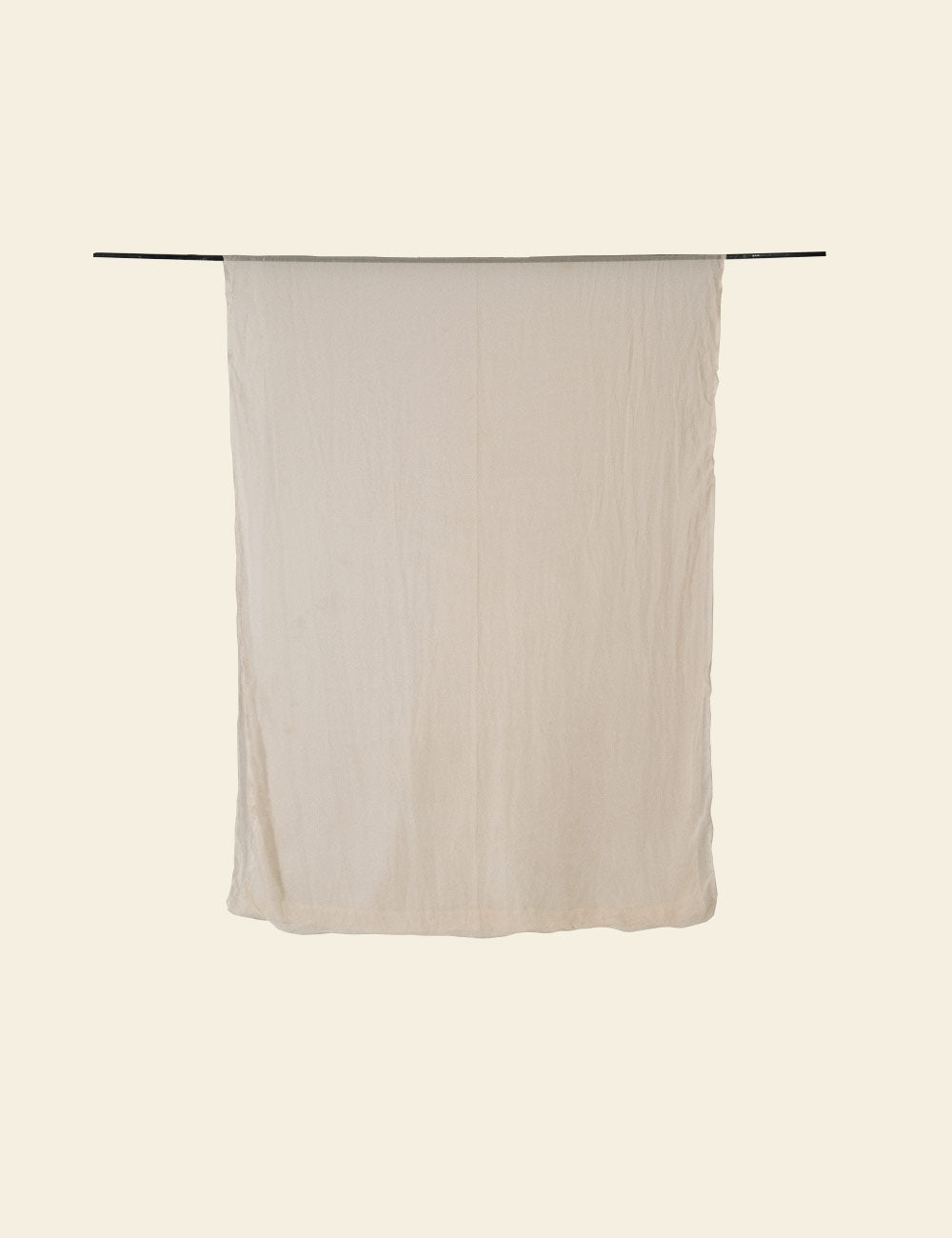 Beige towel hanging on a rod against a beige background
