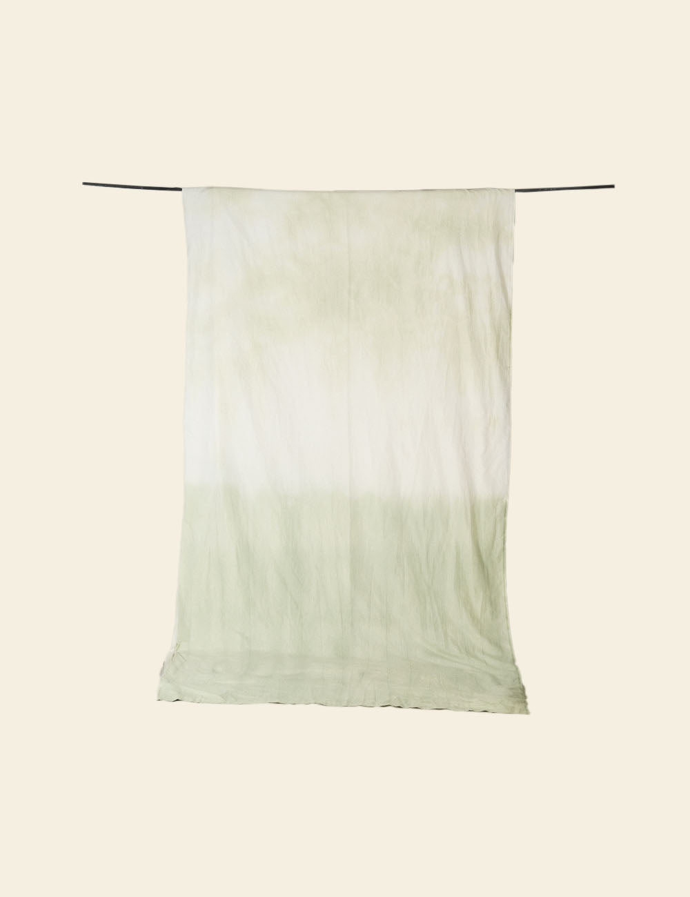 Gradient towel hanging on a rod with a plain background