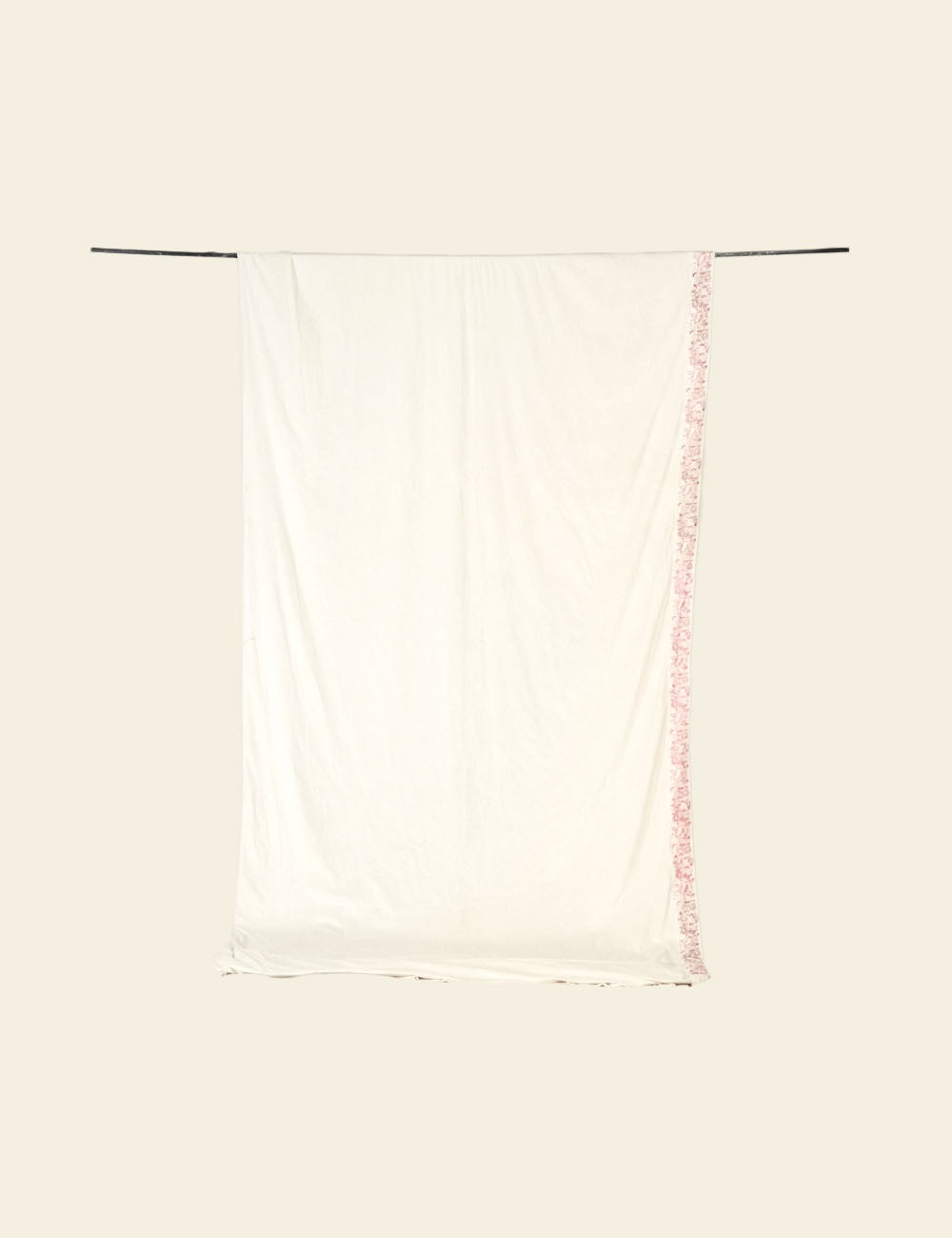 White tank top with pink trim on a beige background