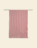 Red and white striped towel hanging on a rack against a beige background
