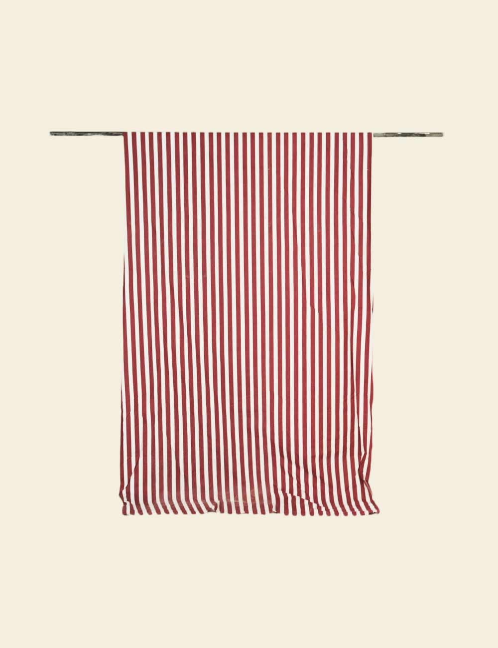 Red and white striped towel hanging on a rack against a beige background