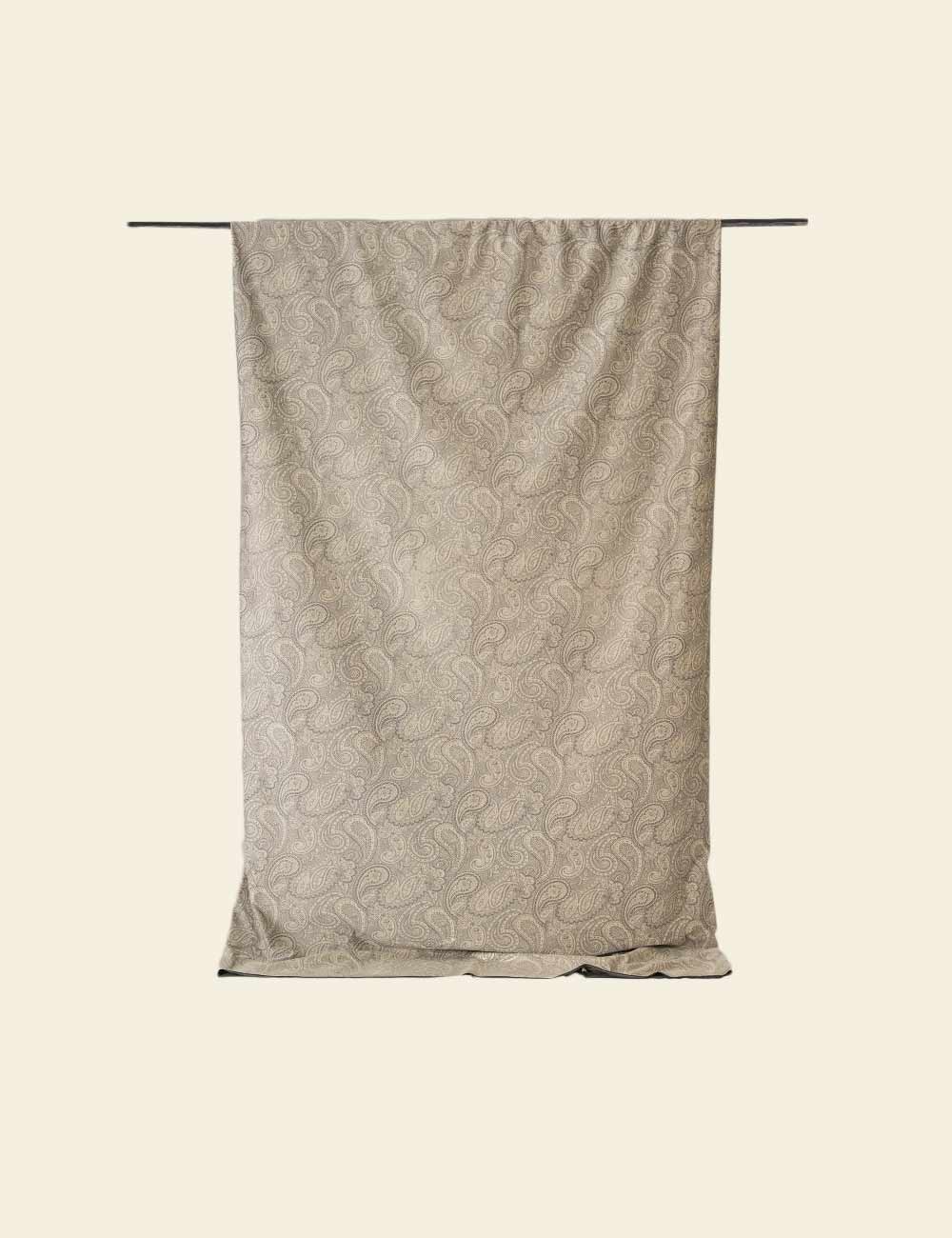 Textured fabric with a subtle pattern draped over a rod on a beige background