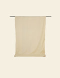 Beige towel hanging on a rack against a beige background
