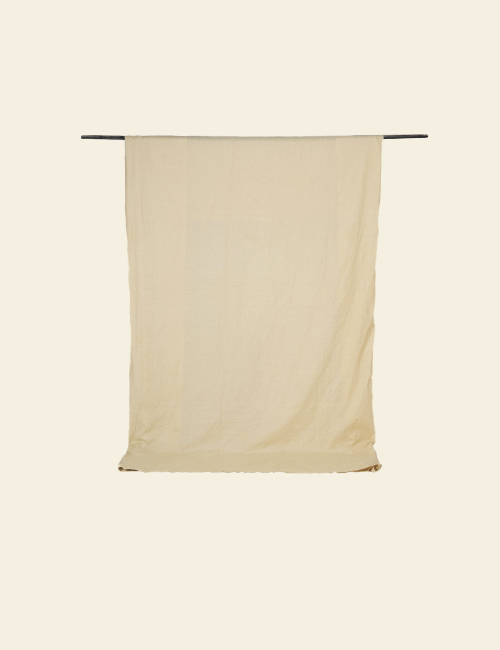 Beige towel hanging on a rack against a beige background